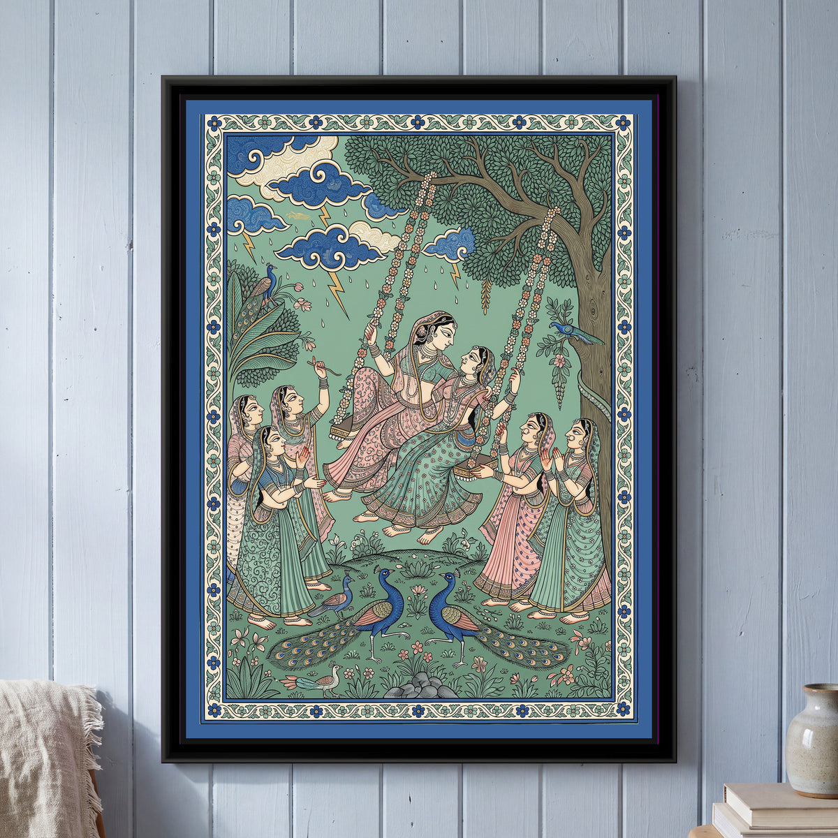 Phad Painting – Ladies on a Monsoon Swing - framed canvas print of ladies on a garlanded swing under monsoon clouds with peacocks, Phad style, hung on a wall