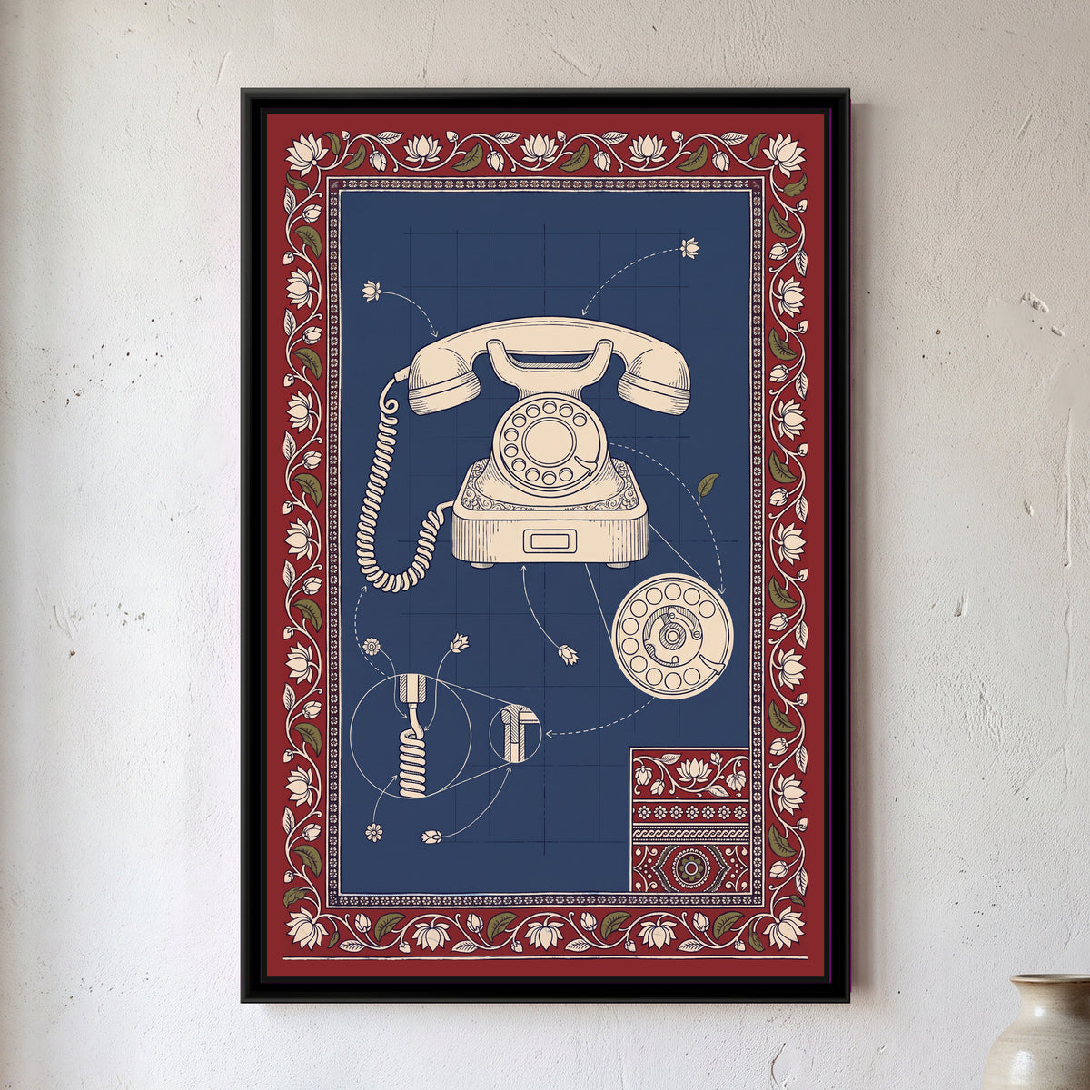 Kalamkari Blueprint – Rotary Telephone - framed canvas print of a cream line drawing of a vintage rotary telephone with a coiled cord on an indigo blueprint grid, with detail circles of the dial mechanism and the cord joint, flower-tipped pointer lines, a small patterned swatch in one corner, deep red border of lotuses and leaves, hung on a wall
