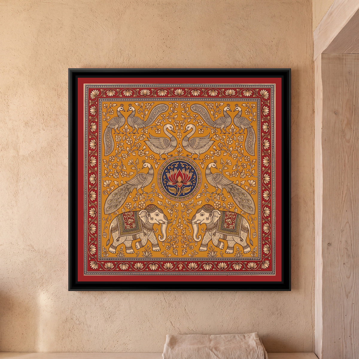 Kalamkari Painting – Elephant and Peacock Mandala - framed canvas print of two cream elephants in decorated red and green saddle cloths and caps facing each other at the bottom, a pair of peacocks with long sweeping tails above them, two swans facing each other at the top and peacock pairs in the upper corners, all around a round indigo medallion with a single red lotus, cream flowering creepers on a mustard ochre ground, inside a madder red border of cream lotuses on a trailing vine, hung on a wall