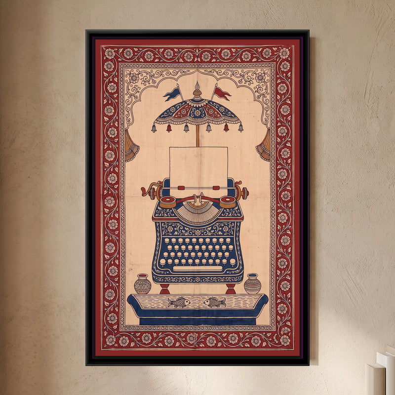Kalamkari Painting – Typewriter - framed canvas print of a vintage typewriter with a blank sheet of paper in the roller, its body covered in cream flowers on indigo, a red and indigo parasol canopy with bells and flags above inside a scalloped arch, two pots and a pond with two fish below, deep red floral border, hung on a wall