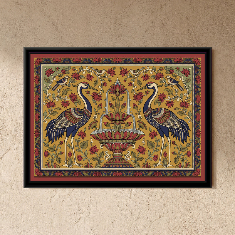 Kalamkari Painting – Cranes Flanking a Lotus Fountain - framed canvas print of two tall cranes with indigo necks and richly patterned red, indigo and cream wings standing face to face on either side of a tiered lotus fountain with water falling in arcs into a lotus basin, small birds perched on curling vines above, red lotus flowers and green leaves on a mustard ground with sage corners, an indigo and red floral border, hung on a wall