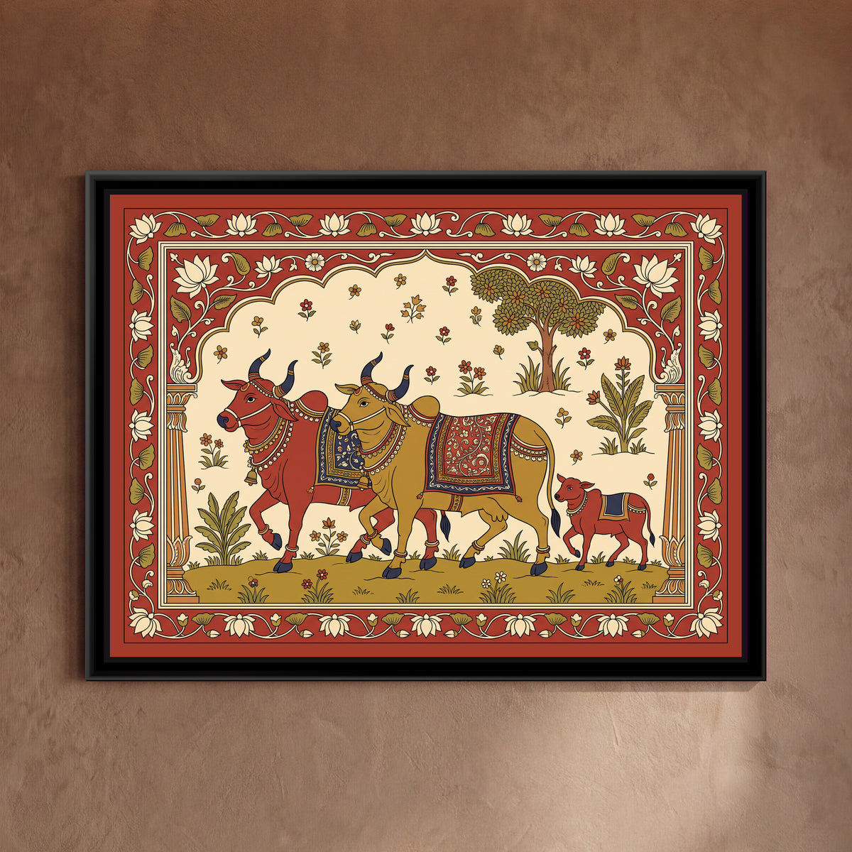 Kalamkari Painting – Decorated Bullocks Procession - framed canvas print of two bullocks, one red and one ochre, with indigo horns, bead necklaces, bells, anklets and patterned saddle cloths walking side by side across a green meadow, a little red calf following behind, a leafy tree, plants and scattered flowers in a cream sky, a scalloped arch on two pillars, a red border of cream lotuses and green leaves on a vine, hung on a wall