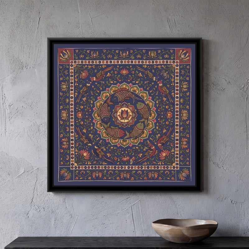 Kalamkari Painting – Fish Mandala – Deep Indigo - framed canvas print of five scaled fish in red, indigo and olive swimming in a ring around a central lotus medallion inside a circle of green and mustard petals, eight parrots in pairs perched among lotus vines at the corners, all on a deep indigo ground, a cream band of tiny flowers, an outer indigo border of lotus vines with two red corner squares at the top, hung on a wall