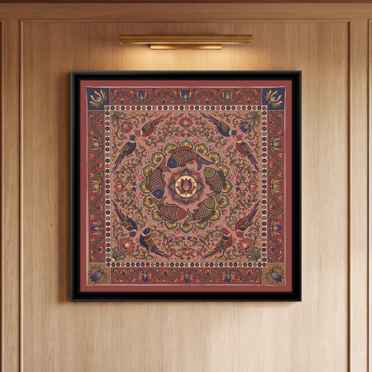 Kalamkari Painting – Fish Mandala – Dusty Rose - framed canvas print of five scaled fish in red, indigo and olive swimming in a ring around a central lotus medallion inside a circle of green and mustard petals, eight parrots in pairs among lotus vines, all on a dusty rose pink ground, a cream band of tiny flowers, an outer madder red border of lotus vines with indigo and mustard corner squares, hung on a wall