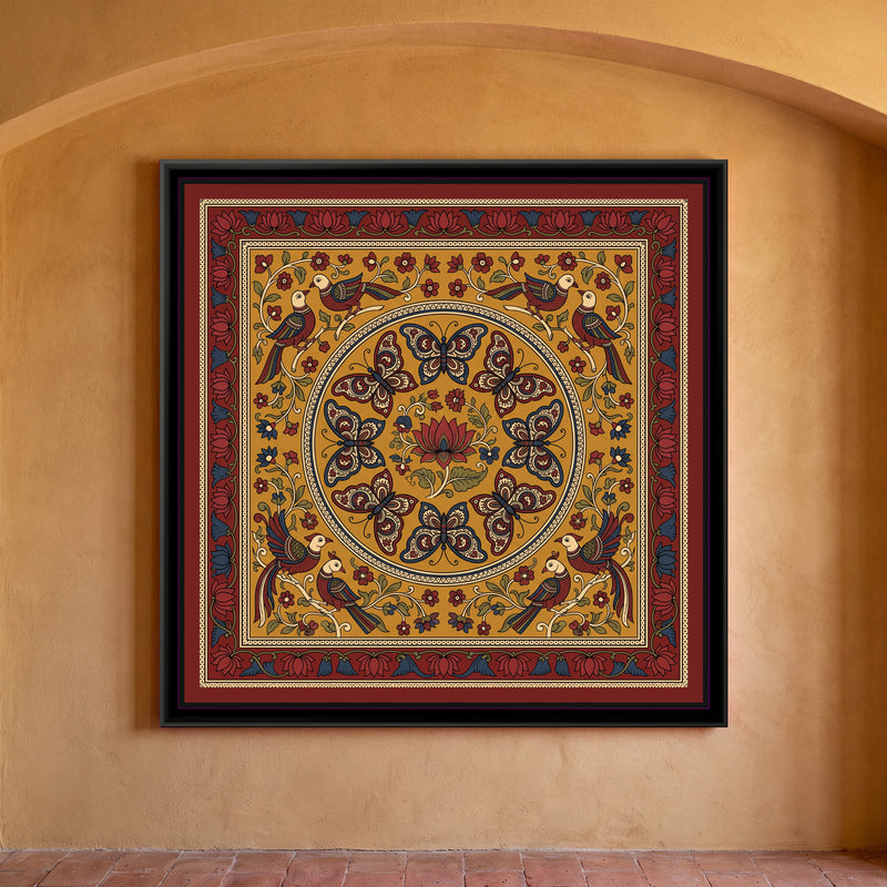 Kalamkari Painting – Butterfly Mandala - framed canvas print of eight butterflies with paisley-patterned wings in indigo, red and cream arranged in a ring around a single red lotus with leaves inside a large circular medallion, four pairs of long-tailed birds perched on cream branches in the corners among small red and blue flowers, all on a mustard yellow ground, inside a deep red border of red and blue lotuses, hung on a wall